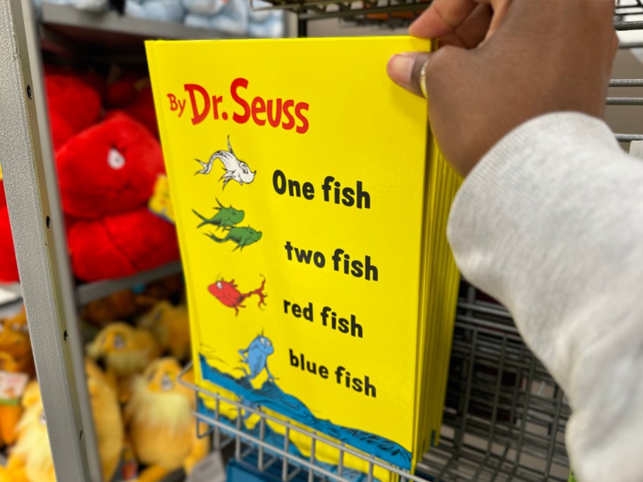 hand reaching for dr suess fish book on shelf