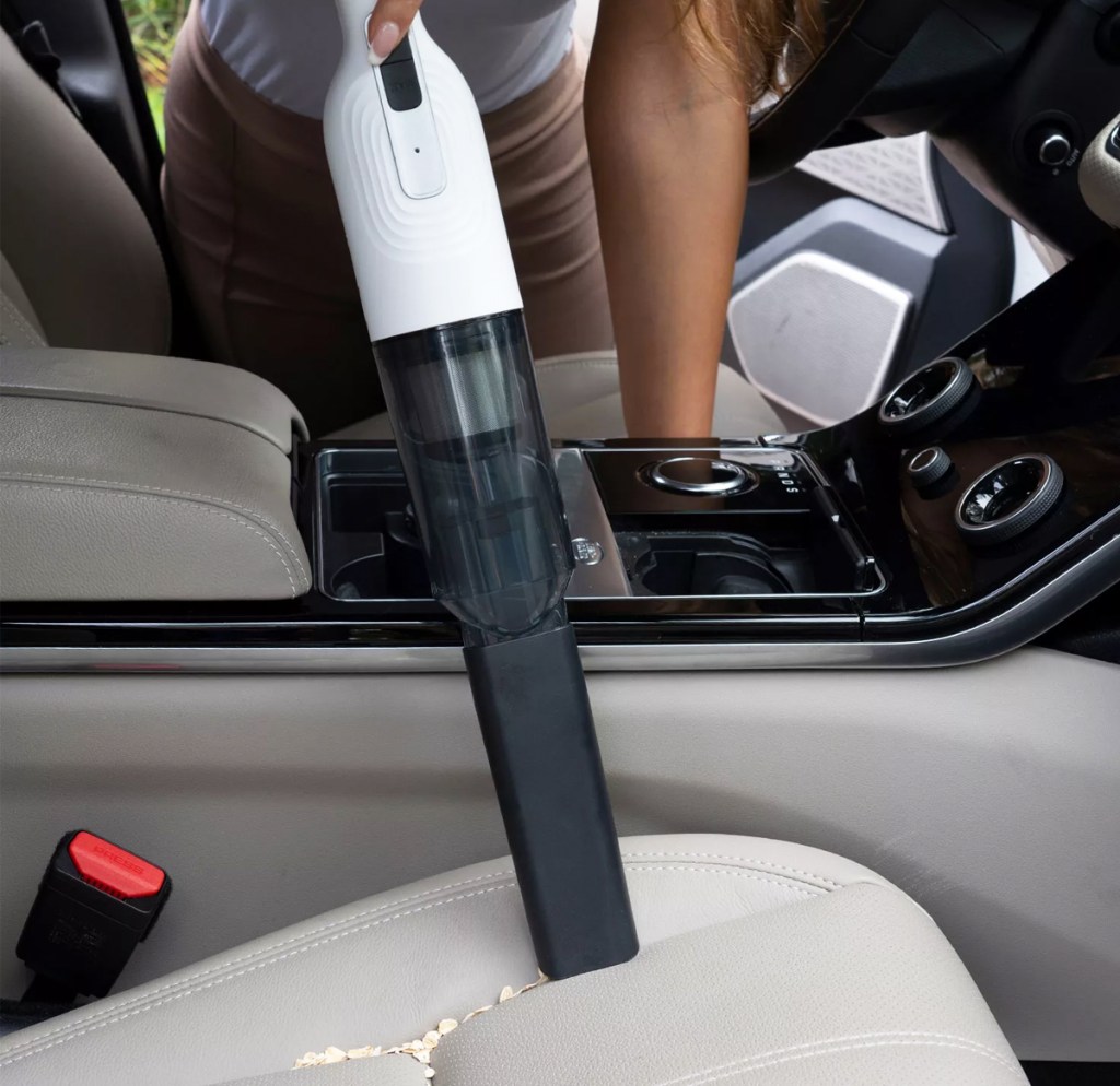 using white and black cordless vacuum in car
