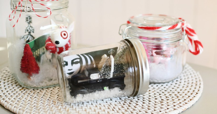 glass snow globe jars on counter with gift cards inside