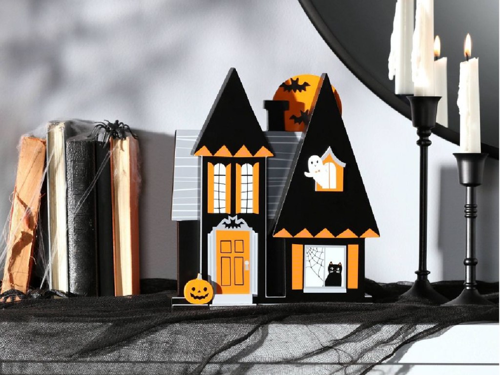 halloween Wood Mini Mantle House displayed on mantle with books and candles