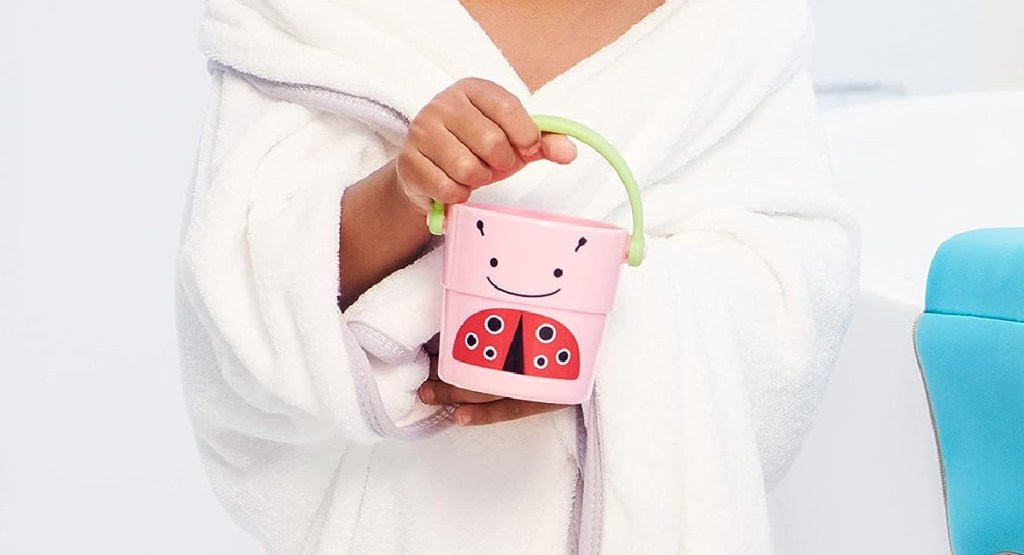 hand holding pink water bucket