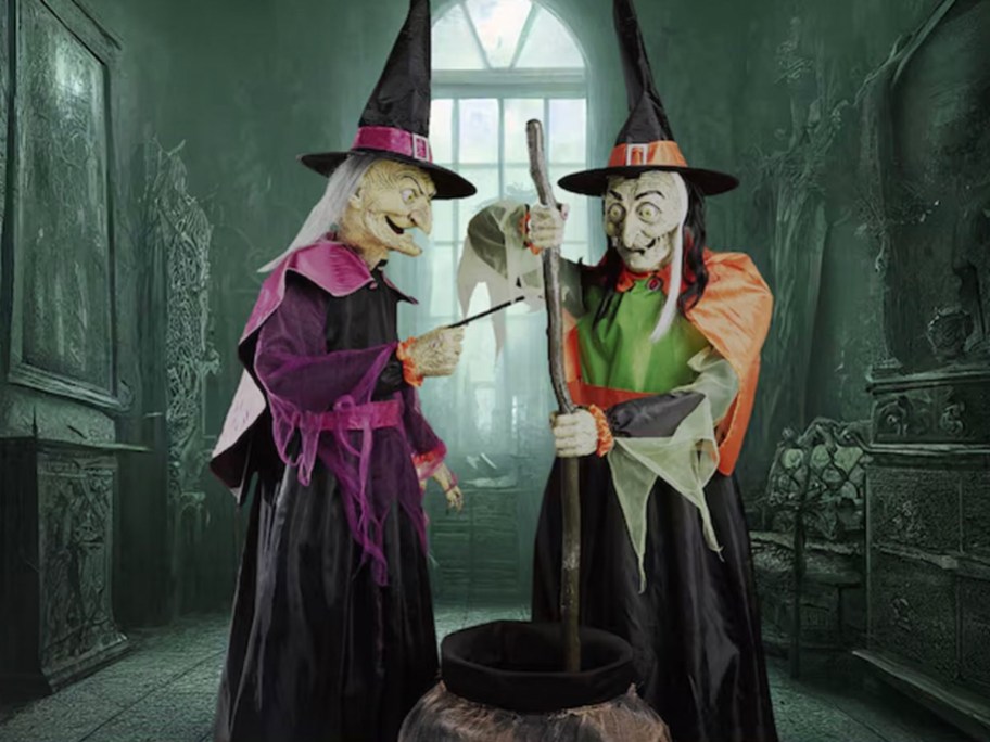 two witch animatronics stirring cauldron in haunted room