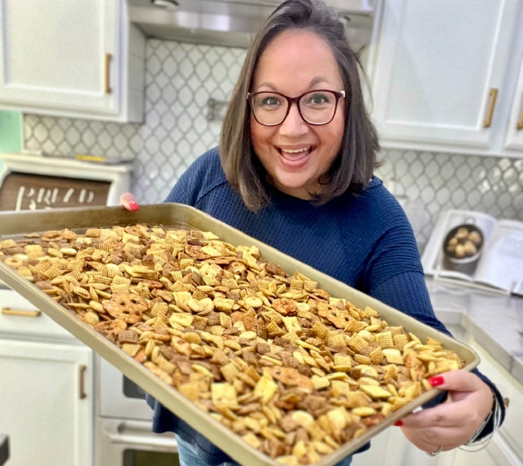 holding a sheet pan with homemade chex mix