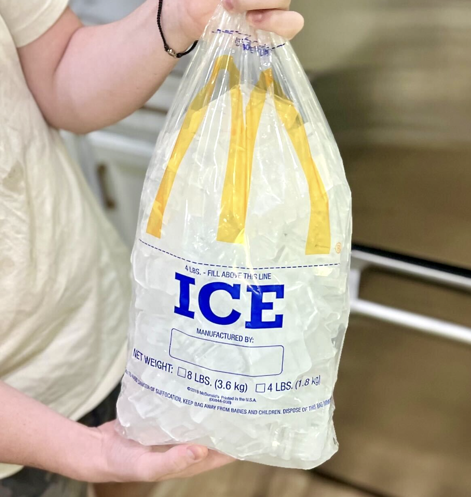 boy holding large bag of ice 