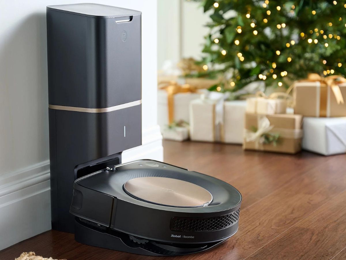 iRobot Roomba vacuum at charging station with christmas tree in background