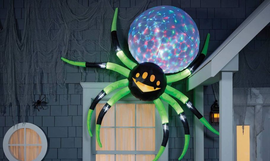 8 foot inflatable spider hanging over the top corner of a window