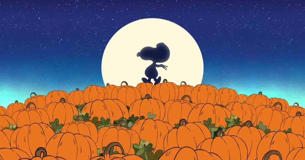 Snoopy's silhouette against a moon in a pumpkin patch