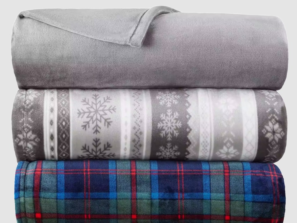 three stacked folded holiday blankets 