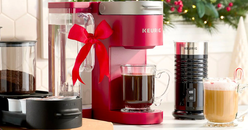 red keurig machine brewing coffee into mug on counter with accessories