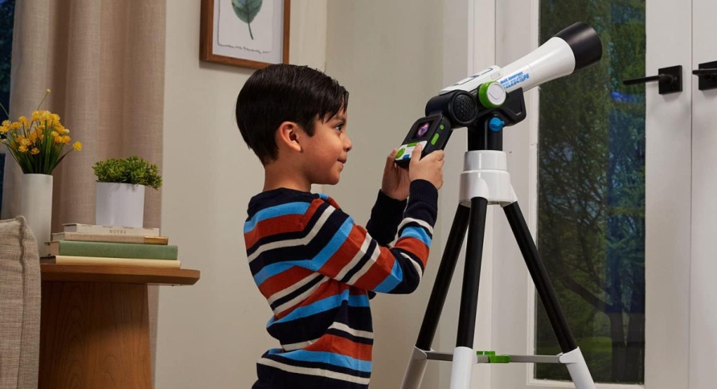 kid looking through his telescope from his bedroom