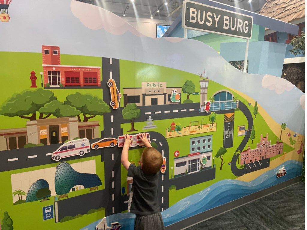 boy playing at kids museum with cars