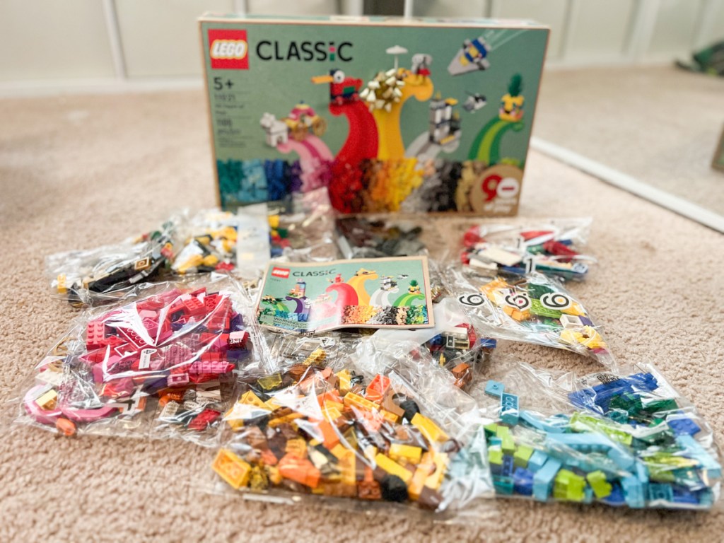lego box with the contents in individual plastic bags spread out on the floor in front of it