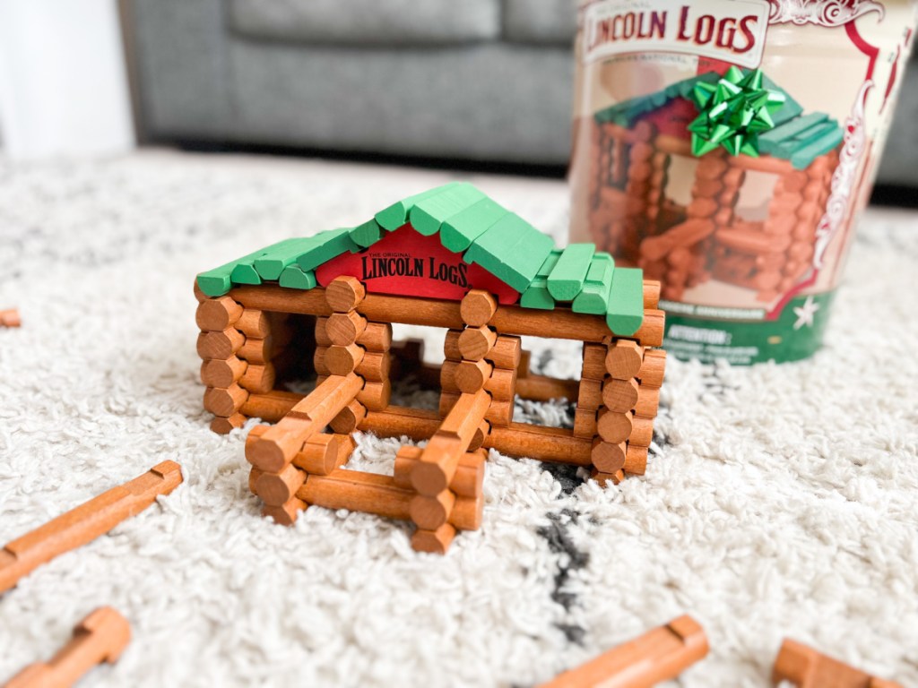 lincoln logs cabin next to anniversary tin with bow
