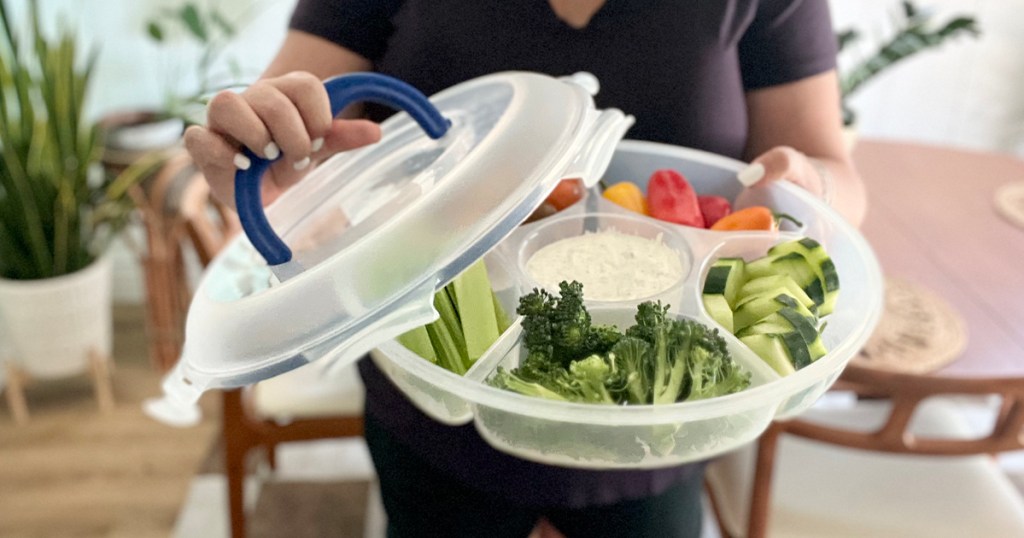 woman lifting off lid of locknlock tray with veggies inside