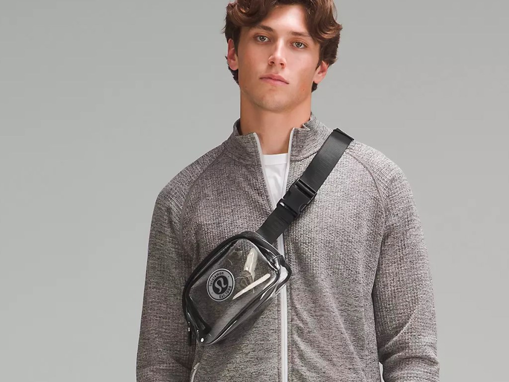 man in gray jacket wearing clear beltbag