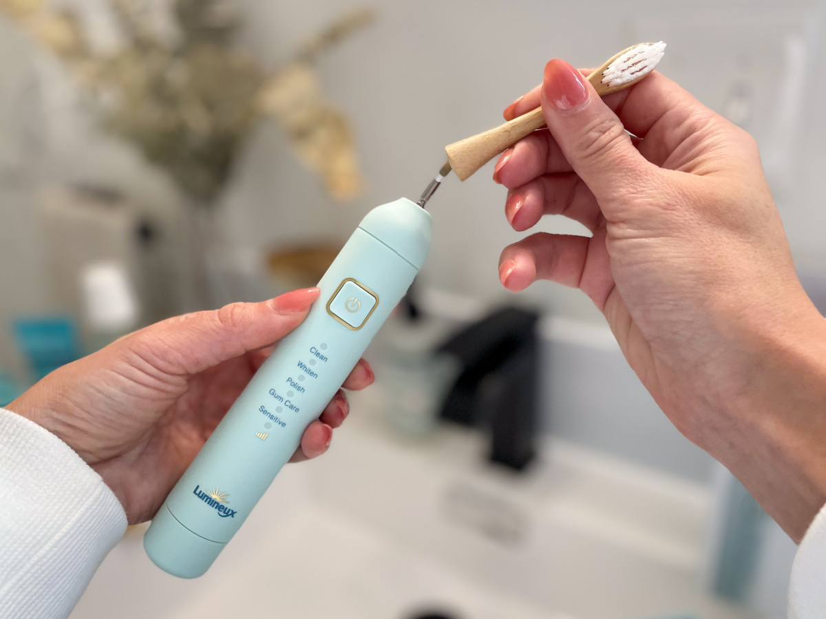 hands removing electric toothbrush head