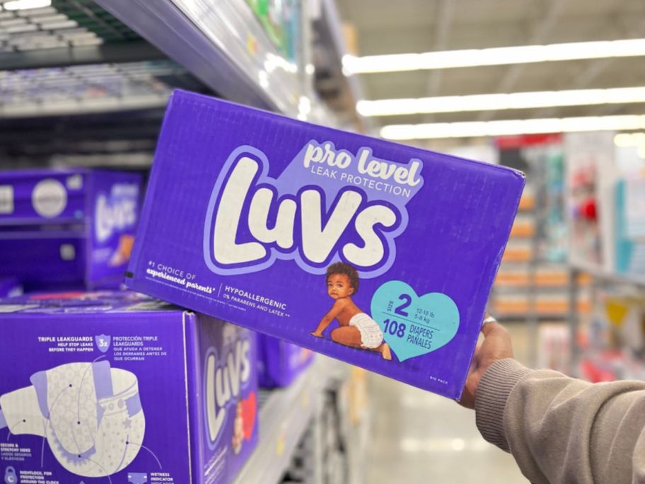 luvs diapers being held in store aisle