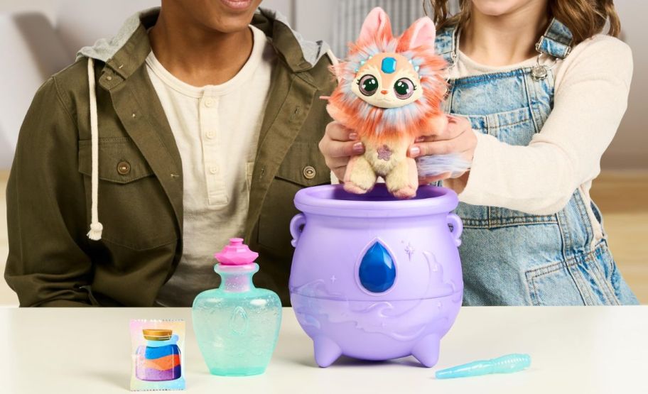 two kids playing with a magic mixies color magic cauldron