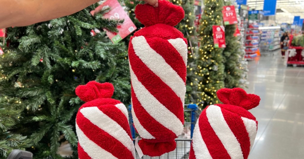 holding up a red and white striped peppermint pillow