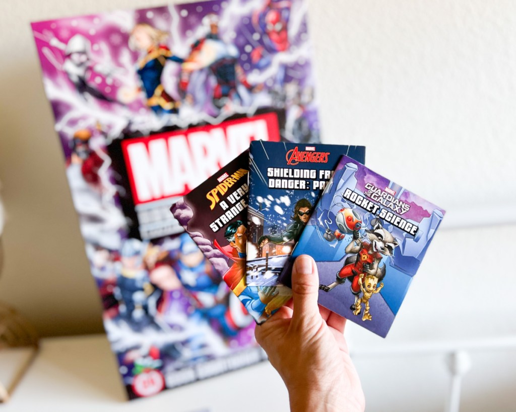 hand holding mini books over advent calendar