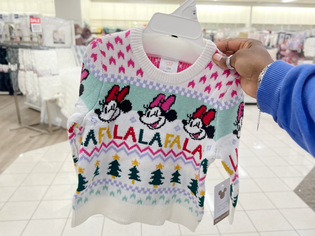 hand holding white minnie mouse sweater