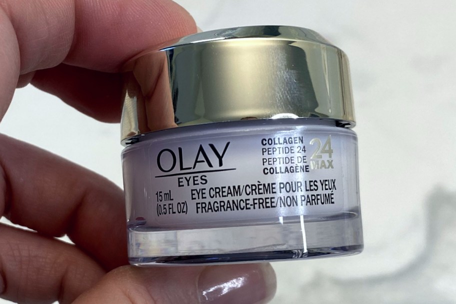 hand holding olay eye cream jar