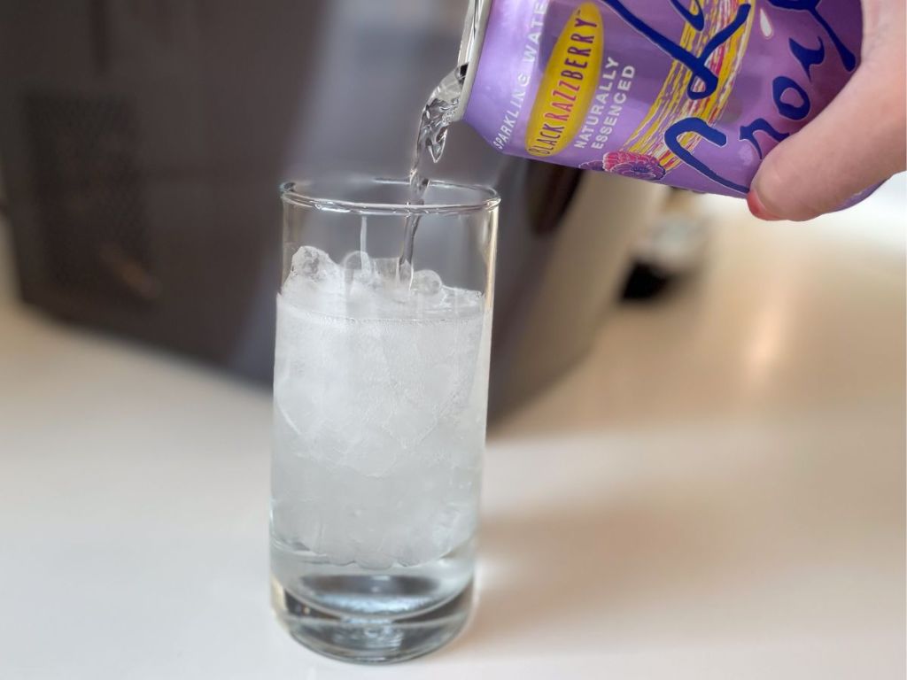 person pouring LaCroix into glass of ice