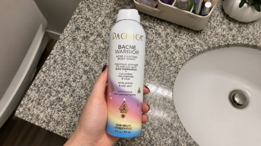 womans hand holding a can of anti acne body spray