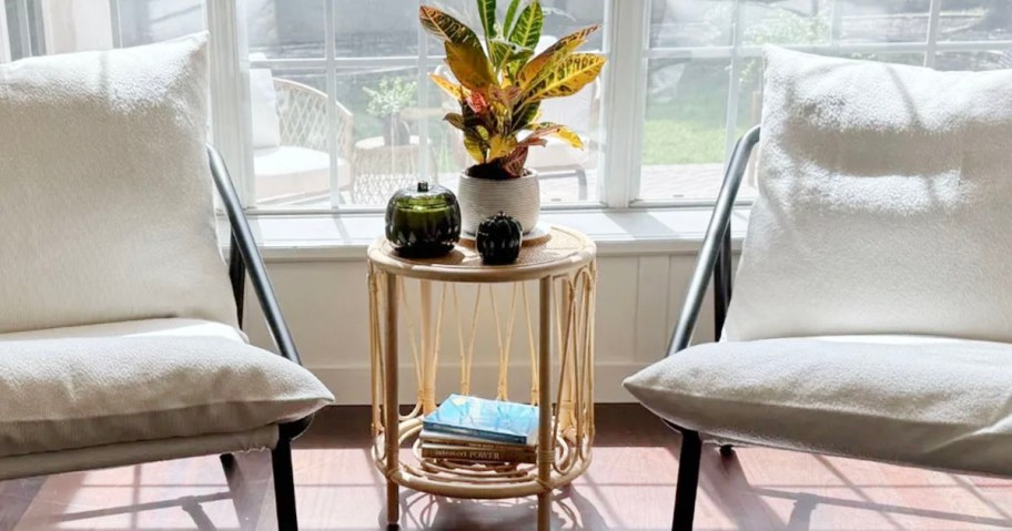rattan table in between two white chairs