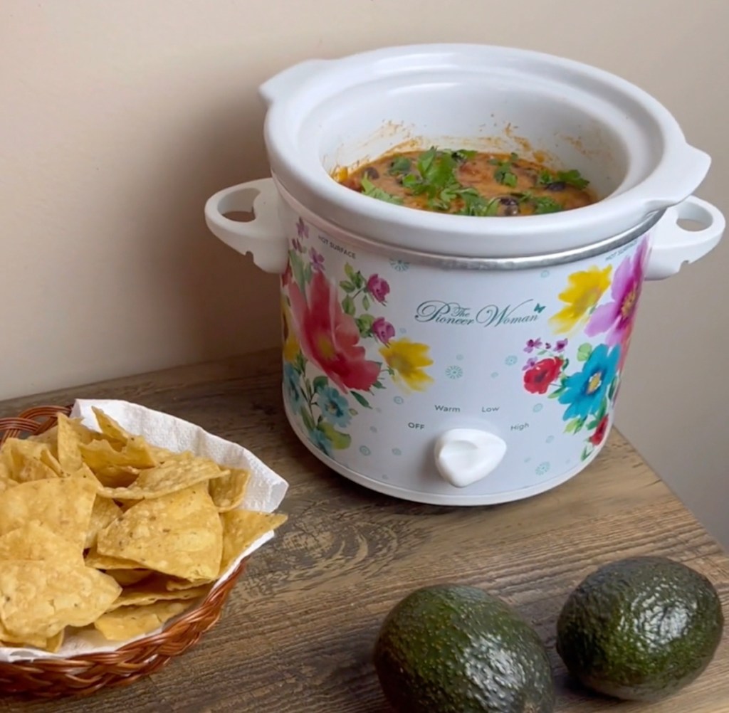 floral pioneer woman crockpot on table with dip chips and avocados
