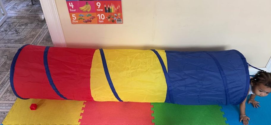 baby crawling out of pop up play tunnel