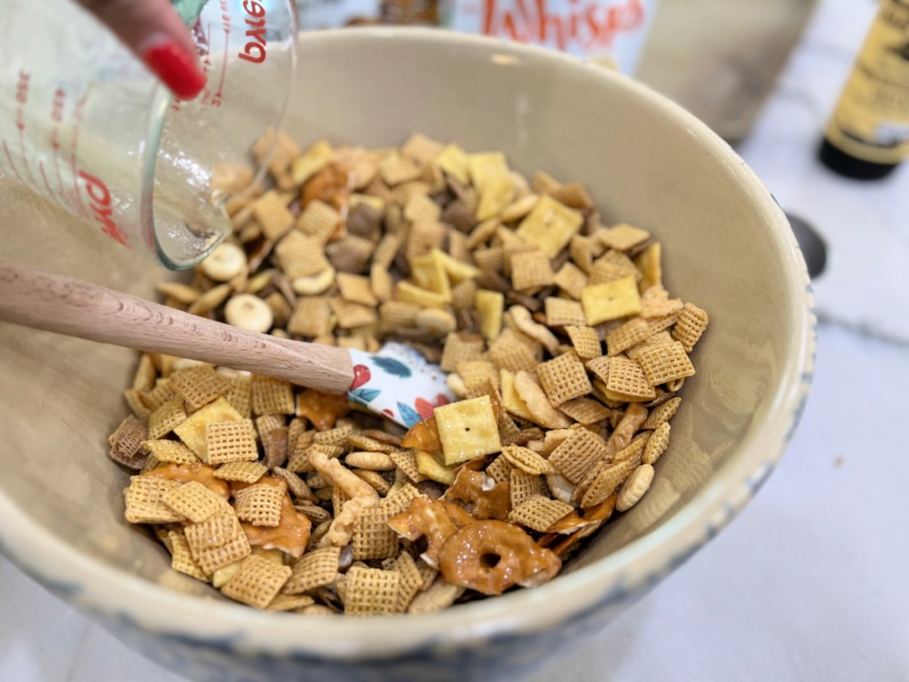 pouring butter on snack mix