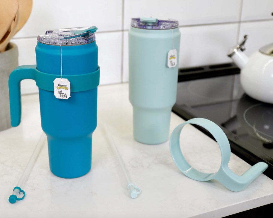 blue and light blue straw tumblers with tea bags sticking out