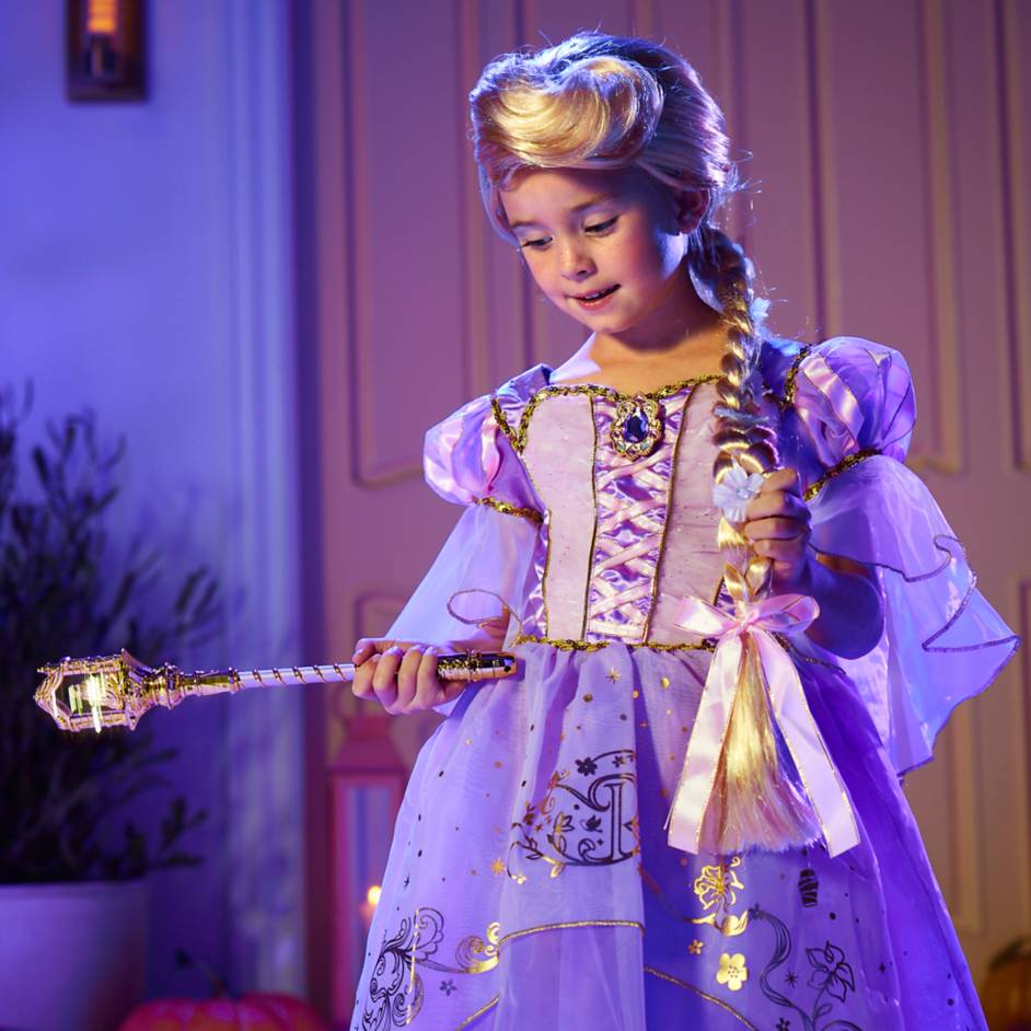 young girl wearing a disney rapunzel costume holding a light up wand