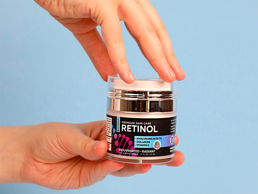hands holding raw science retinol cream jar