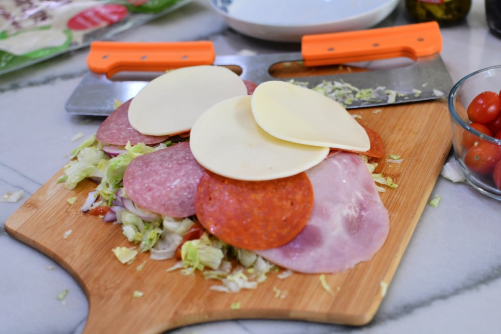 sliced meat and cheeses on a cutting board