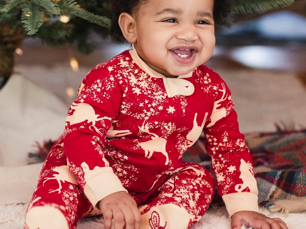 baby wearing red reindeer pajamas
