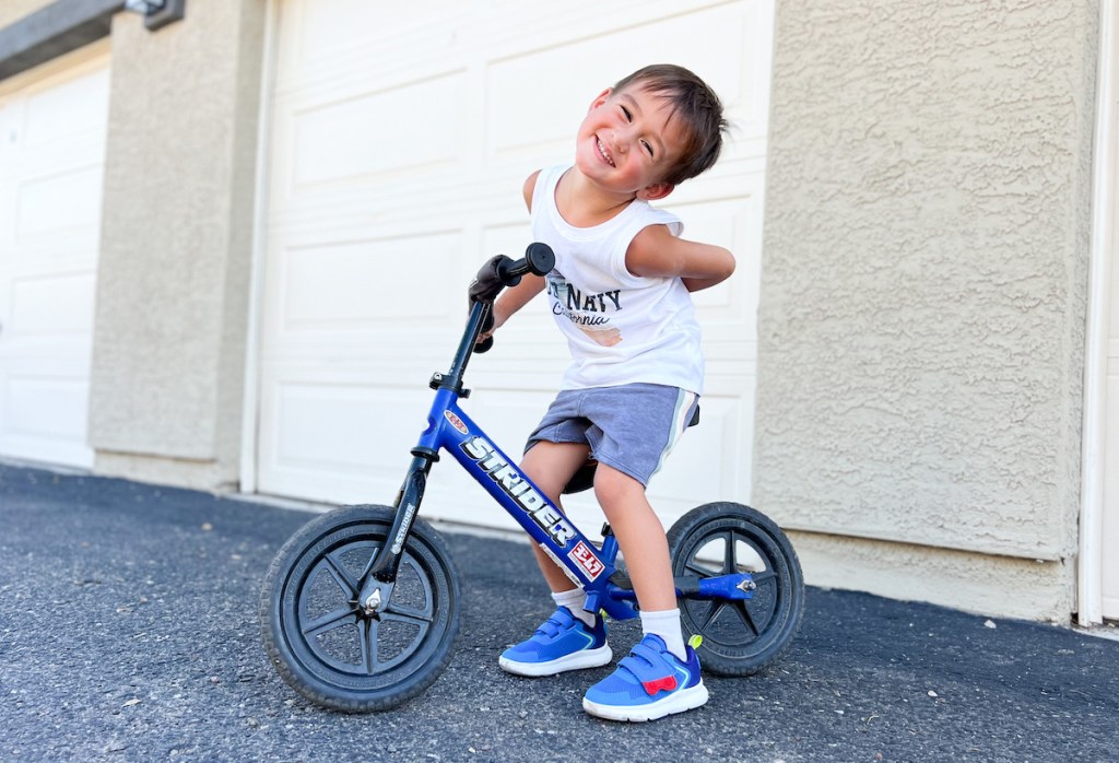 boy on blue strider bike on pavement