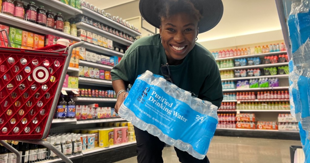 woman holding case of water at Target