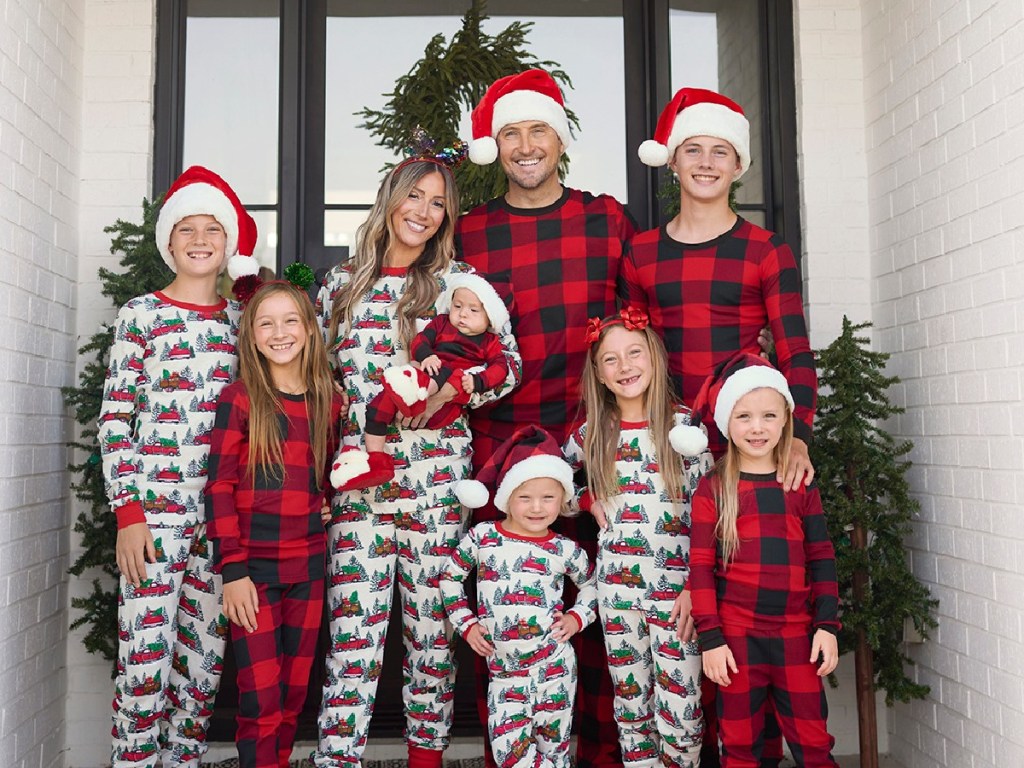 family posing in front of a door wearing the childrens place holiday pajamas