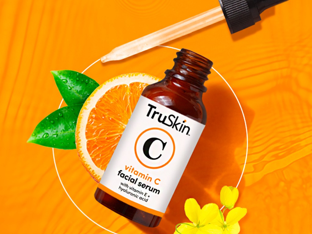 truskin vitamin c face serum bottle with dropper on orange background