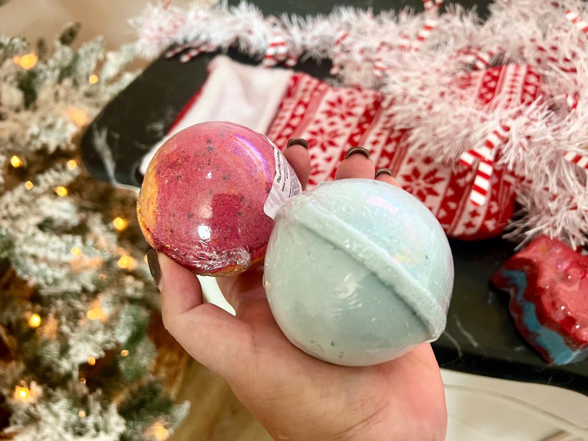 Fragrant Jewels Bath Bombs in person's hand with Christmas stocking in background