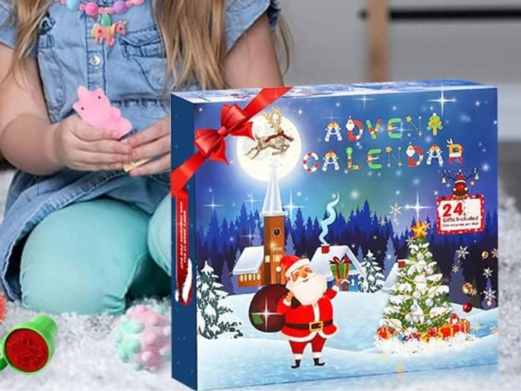 A girl sitting on the floor playing with a 2023 Advent Calendar