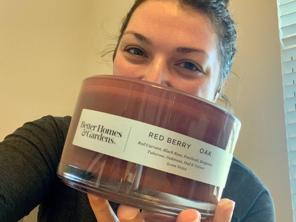 Alli holding up a Better Homes & Gardens 3-Wick Candle in Red Berry & Oak 