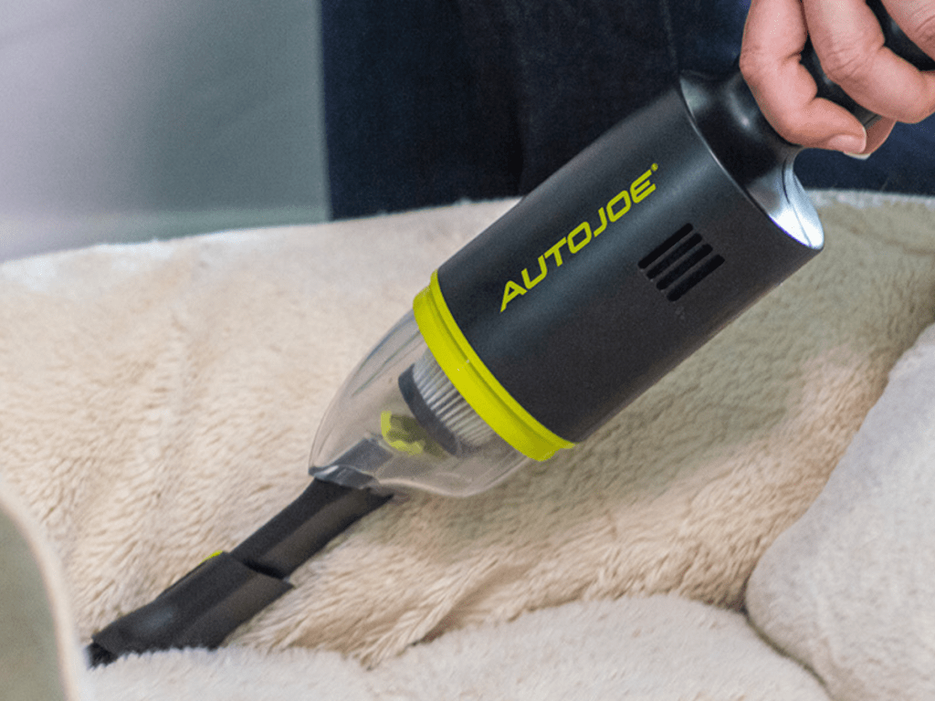 person cleaning a dog bed using the Auto Joe 8.4V Cordless Handheld Vacuum Cleaner with HEPA Filter