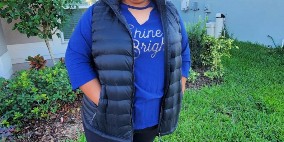 woman in blue shirt wearing black vest