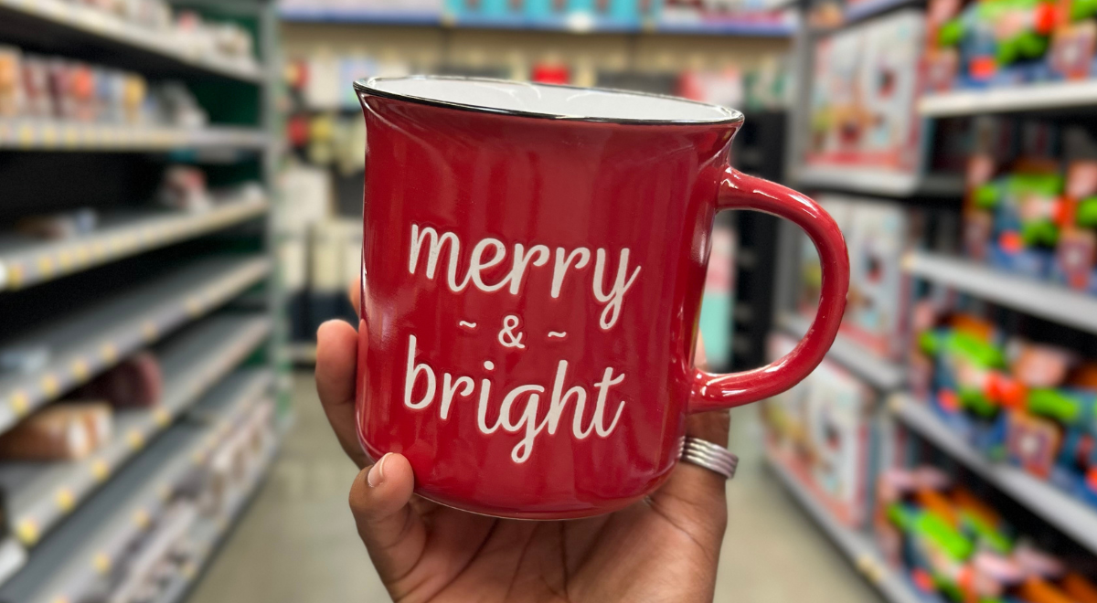 hand holding red merry & bright mug candle