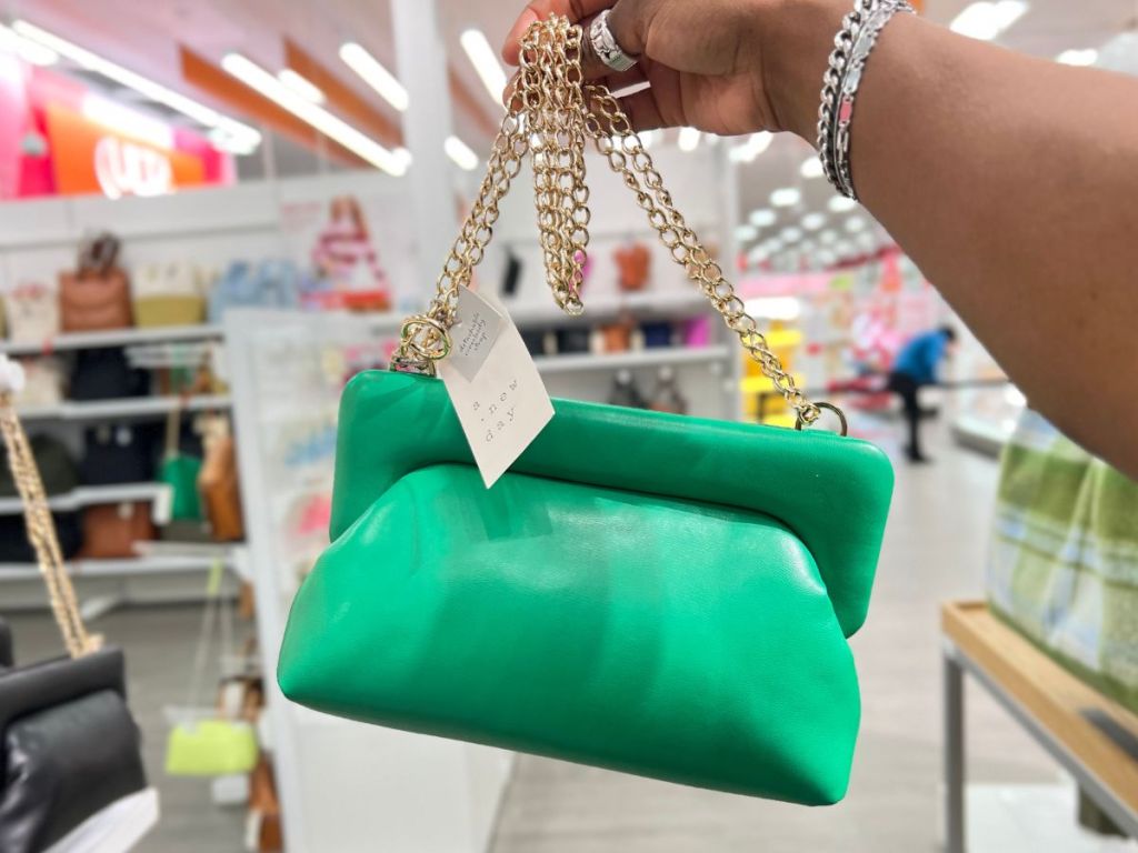 a womans hand displaying A New Day Puff Clutch in Green