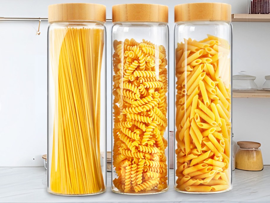 various pastas inside 3 tall glass storage containers
