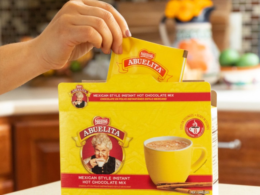hand removig a packet of Abuelita hot chocolate mix from a box